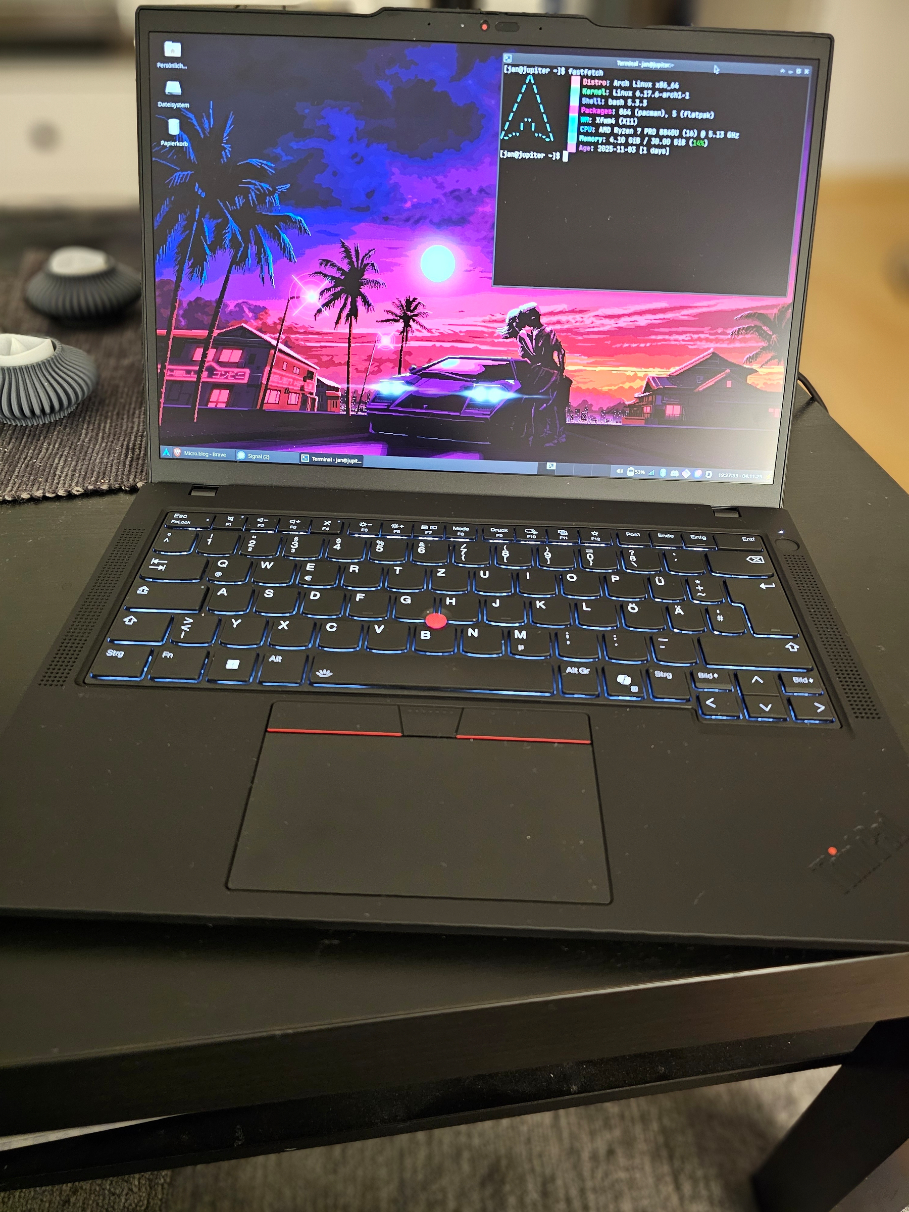 Auto-generated description: Ein Laptop mit einem Neon-Stadtszene-Hintergrund zeigt ein Terminalfenster mit Systeminformationen.